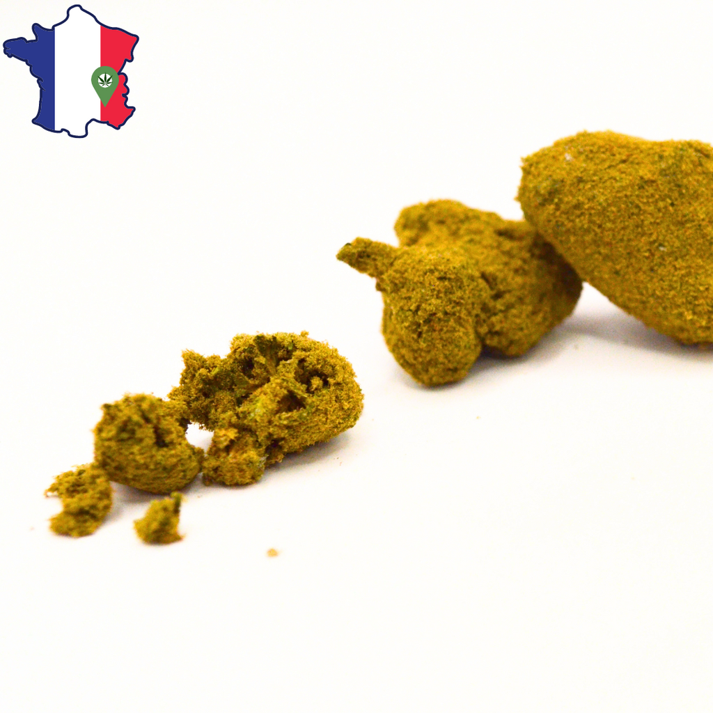 Moonrocks CBD/CBN entières et émiettées, avec des fragments de fleur et de pollen au premier plan.